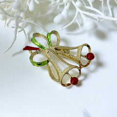 Vintage Gerry’s Christmas bells brooch in gold tone metal with red and green enamel ribbon, signed on back, festive mid-century holiday jewelry.
