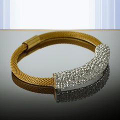 Gold tone mesh bracelet with a curved white centerpiece set with clear rhinestones over silver foil backing, creating a bright silvery shimmer; finished with a magnetic clasp and sleek modern design.