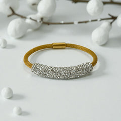Gold tone mesh bracelet with a curved white centerpiece set with clear rhinestones over silver foil backing, creating a bright silvery shimmer; finished with a magnetic clasp and sleek modern design.