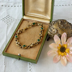 Vintage Goldette N.Y. bracelet with alternating green cabochons and faux pearls in textured gold‑tone curb links, fold‑over clasp signed Goldette N.Y.