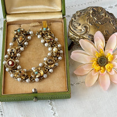 Vintage Goldette NY Victorian Revival bracelet with faux pearls, floral and animal motifs, cameo, and gold‑tone links showing gentle patina.