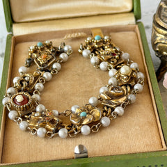 Vintage Goldette NY Victorian Revival bracelet with faux pearls, floral and animal motifs, cameo, and gold‑tone links showing gentle patina.