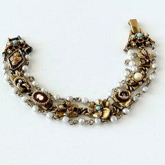 Vintage Goldette NY Victorian Revival bracelet with faux pearls, floral and animal motifs, cameo, and gold‑tone links showing gentle patina.