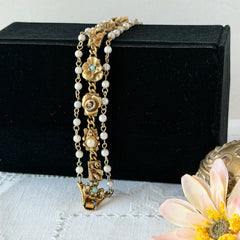Vintage Goldette NY Victorian Revival bracelet with faux pearls, floral and animal motifs, cameo, and gold‑tone links showing gentle patina.