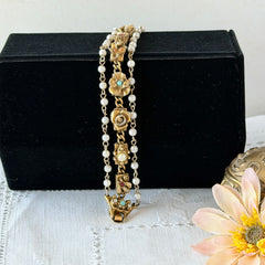 Vintage Goldette NY Victorian Revival bracelet with faux pearls, floral and animal motifs, cameo, and gold‑tone links showing gentle patina.