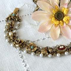 Vintage Goldette NY Victorian Revival bracelet with faux pearls, floral and animal motifs, cameo, and gold‑tone links showing gentle patina.