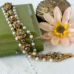 Vintage Goldette NY Victorian Revival bracelet with faux pearls, floral and animal motifs, cameo, and gold‑tone links showing gentle patina.