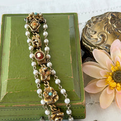 Vintage Goldette NY Victorian Revival bracelet with faux pearls, floral and animal motifs, cameo, and gold‑tone links showing gentle patina.