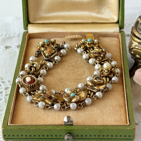 Vintage Goldette NY Victorian Revival bracelet with faux pearls, floral and animal motifs, cameo, and gold‑tone links showing gentle patina.