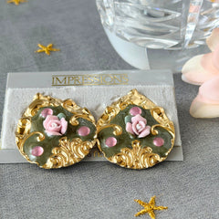 Vintage 1980s teardrop post earrings with 3D pink polymer clay rose, green enamel base, and gold tone pressed metal scrollwork on original card.