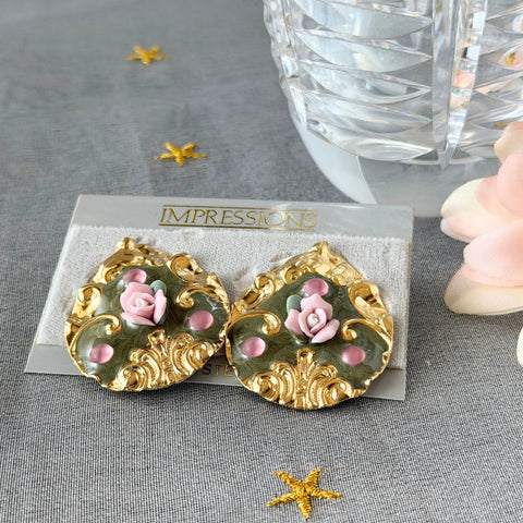 Vintage 1980s teardrop post earrings with 3D pink polymer clay rose, green enamel base, and gold tone pressed metal scrollwork on original card.