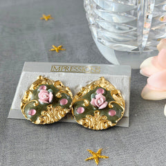 Vintage 1980s teardrop post earrings with 3D pink polymer clay rose, green enamel base, and gold tone pressed metal scrollwork on original card.