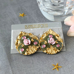 Vintage 1980s teardrop post earrings with 3D pink polymer clay rose, green enamel base, and gold tone pressed metal scrollwork on original card.