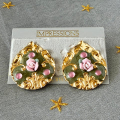 Vintage 1980s teardrop post earrings with 3D pink polymer clay rose, green enamel base, and gold tone pressed metal scrollwork on original card.
