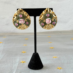 Vintage 1980s teardrop post earrings with 3D pink polymer clay rose, green enamel base, and gold tone pressed metal scrollwork on original card.