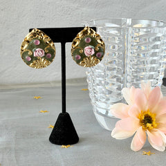 Vintage 1980s teardrop post earrings with 3D pink polymer clay rose, green enamel base, and gold tone pressed metal scrollwork on original card.