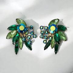Vintage 1960s clip-on floral earrings with green and iridescent rhinestones in chaton, navette, and marquise cuts, set in gold-tone metal—sparkling midcentury costume jewelry in very good condition.