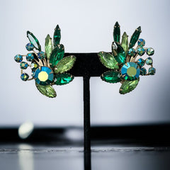 Vintage 1960s clip-on floral earrings with green and iridescent rhinestones in chaton, navette, and marquise cuts, set in gold-tone metal—sparkling midcentury costume jewelry in very good condition.