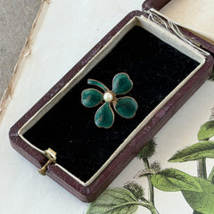 Vintage green guilloché enamel four‑leaf clover brooch with faux pearl center and rose gold tone finish.