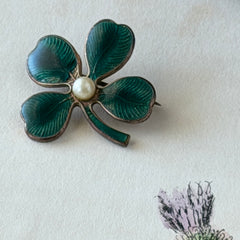 Vintage green guilloché enamel four‑leaf clover brooch with faux pearl center and rose gold tone finish.