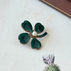 Vintage green guilloché enamel four‑leaf clover brooch with faux pearl center and rose gold tone finish.