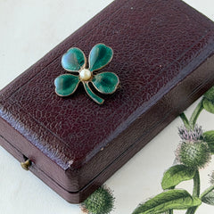 Vintage green guilloché enamel four‑leaf clover brooch with faux pearl center and rose gold tone finish.