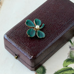 Vintage green guilloché enamel four‑leaf clover brooch with faux pearl center and rose gold tone finish.