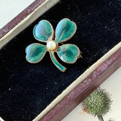 Vintage green guilloché enamel four‑leaf clover brooch with faux pearl center and rose gold tone finish.