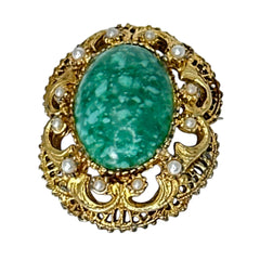 Vintage brooch pendant with mottled green glass cabochon, faux pearls, and ornate gold tone filigree, photographed front and back to highlight its 1960s–70s revival style and dual-wear functionality.