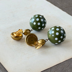 Vintage 1980s green and white polka‑dot plastic ball dangle gold tone statement clip‑on earrings.