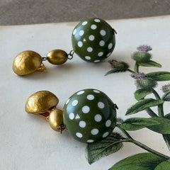 Vintage 1980s green and white polka‑dot plastic ball dangle gold tone statement clip‑on earrings.