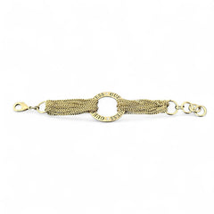 Gold tone Guess bracelet with multi-strand chains and a central ring engraved with ‘GUESS’ and accented by clear rhinestones, shown on neutral backdrop.