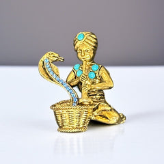 Vintage Hattie Carnegie snake charmer brooch with turquoise cabochons and blue rhinestones, gold tone metal, signed with copyright mark, 1960s figural costume jewelry.