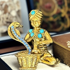 Vintage Hattie Carnegie snake charmer brooch with turquoise cabochons and blue rhinestones, gold tone metal, signed with copyright mark, 1960s figural costume jewelry.