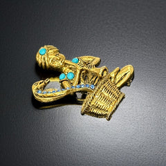 Vintage Hattie Carnegie snake charmer brooch with turquoise cabochons and blue rhinestones, gold tone metal, signed with copyright mark, 1960s figural costume jewelry.