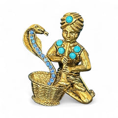 Vintage Hattie Carnegie snake charmer brooch with turquoise cabochons and blue rhinestones, gold tone metal, signed with copyright mark, 1960s figural costume jewelry.