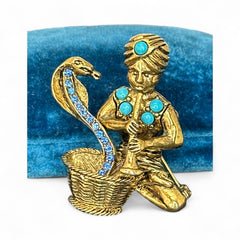 Vintage Hattie Carnegie snake charmer brooch with turquoise cabochons and blue rhinestones, gold tone metal, signed with copyright mark, 1960s figural costume jewelry.