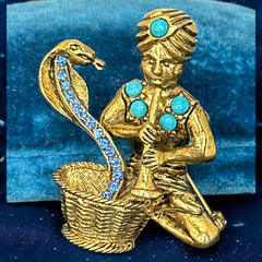Vintage Hattie Carnegie snake charmer brooch with turquoise cabochons and blue rhinestones, gold tone metal, signed with copyright mark, 1960s figural costume jewelry.