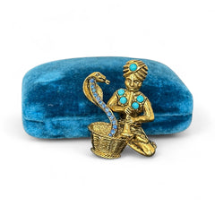 Vintage Hattie Carnegie snake charmer brooch with turquoise cabochons and blue rhinestones, gold tone metal, signed with copyright mark, 1960s figural costume jewelry.