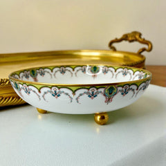 Antique Haviland Limoges France porcelain serving bowl with three gold spherical feet, ornate rim featuring floral and scroll motifs in blue, green, red, and gold; white base with maker’s marks “Haviland France” and “Haviland & Co Limoges”; very good vintage condition with one small factory flaw in center