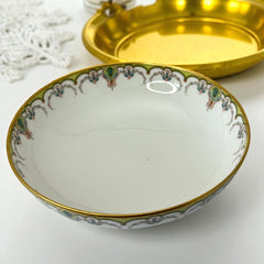 Antique Haviland Limoges France porcelain serving bowl with three gold spherical feet, ornate rim featuring floral and scroll motifs in blue, green, red, and gold; white base with maker’s marks “Haviland France” and “Haviland & Co Limoges”; very good vintage condition with one small factory flaw in center
