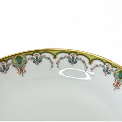 Antique Haviland Limoges France porcelain serving bowl with three gold spherical feet, ornate rim featuring floral and scroll motifs in blue, green, red, and gold; white base with maker’s marks “Haviland France” and “Haviland & Co Limoges”; very good vintage condition with one small factory flaw in center