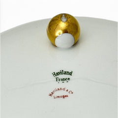 Antique Haviland Limoges France porcelain serving bowl with three gold spherical feet, ornate rim featuring floral and scroll motifs in blue, green, red, and gold; white base with maker’s marks “Haviland France” and “Haviland & Co Limoges”; very good vintage condition with one small factory flaw in center
