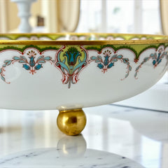 Antique Haviland Limoges France porcelain serving bowl with three gold spherical feet, ornate rim featuring floral and scroll motifs in blue, green, red, and gold; white base with maker’s marks “Haviland France” and “Haviland & Co Limoges”; very good vintage condition with one small factory flaw in center