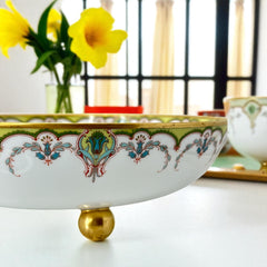 Antique Haviland Limoges France porcelain serving bowl with three gold spherical feet, ornate rim featuring floral and scroll motifs in blue, green, red, and gold; white base with maker’s marks “Haviland France” and “Haviland & Co Limoges”; very good vintage condition with one small factory flaw in center