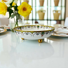 Antique Haviland Limoges France porcelain serving bowl with three gold spherical feet, ornate rim featuring floral and scroll motifs in blue, green, red, and gold; white base with maker’s marks “Haviland France” and “Haviland & Co Limoges”; very good vintage condition with one small factory flaw in center