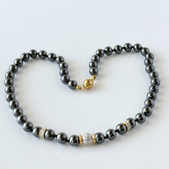 Vintage hematite bead necklace with gold‑tone and silver‑tone accents, hand‑knotted with slide ball clasp.