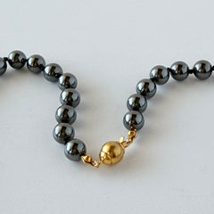 Vintage hematite bead necklace with gold‑tone and silver‑tone accents, hand‑knotted with slide ball clasp.