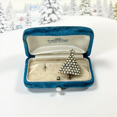 Vintage Hollycraft Christmas tree brooch with clear Aurora Borealis rhinestones in a gold-tone setting, featuring a gold star at the top and a red rhinestone base. Signed on the reverse and measuring approximately 1 3/8 inches tall by 1 inch wide.