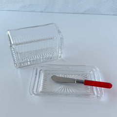Vintage clear glass butter dish with raised “Beurre” lettering visible through the lid and ribbed radiating base.